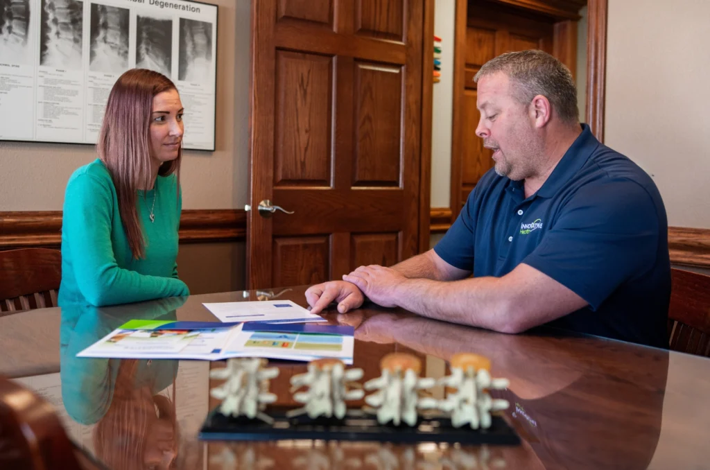Chiropractor reviewing test results with a patient during a consultation