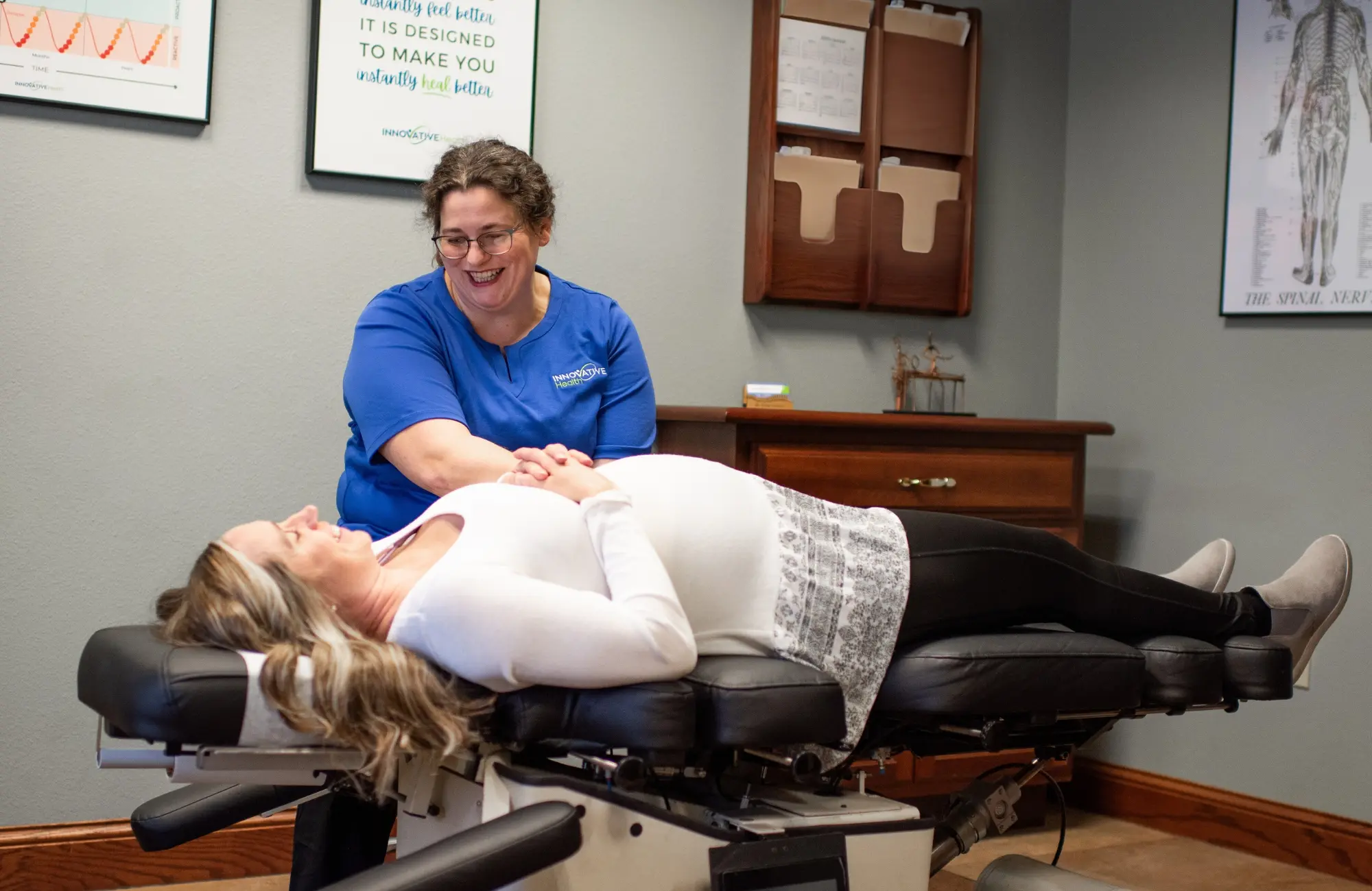 Chiropractor providing care to a woman lying on an adjustment table