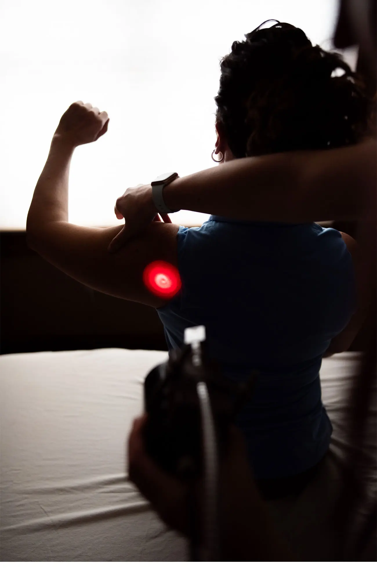 Patient receiving laser therapy on the upper arm and shoulder