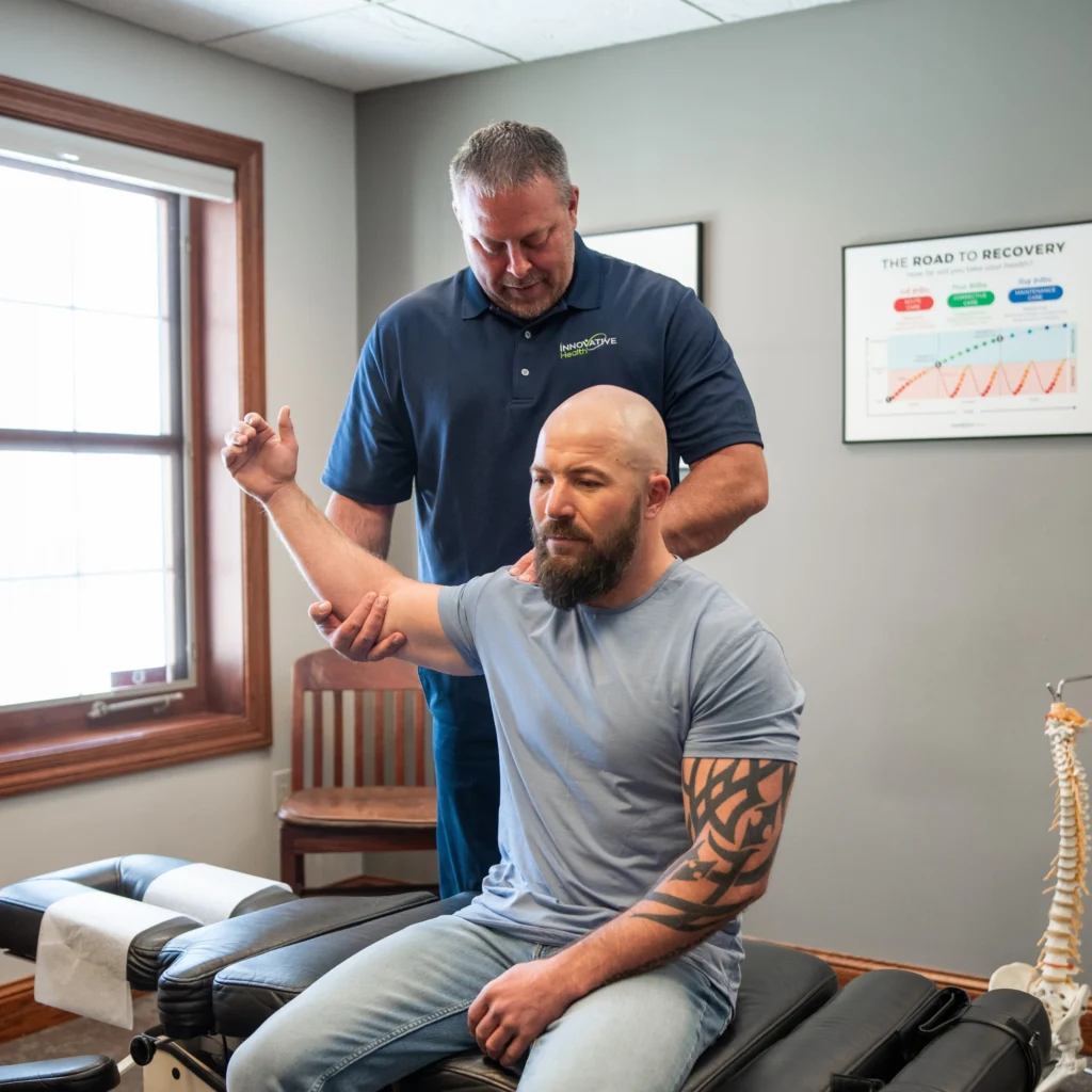 Chiropractor performing shoulder mobility assessment on a male patient